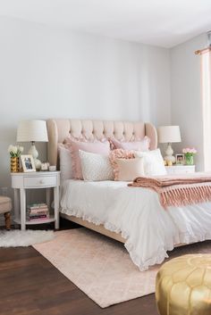 a bedroom with white walls and pink bedding