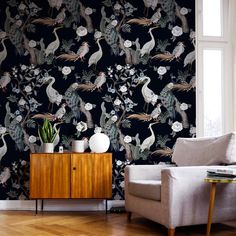 a living room with a couch, chair and wallpaper that has birds on it