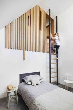 a woman climbing up the side of a wooden slatted wall next to a bed