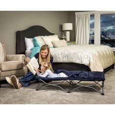 a woman and her child are sitting in a bed with a mattress on the floor