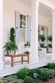 the front porch is decorated with potted plants