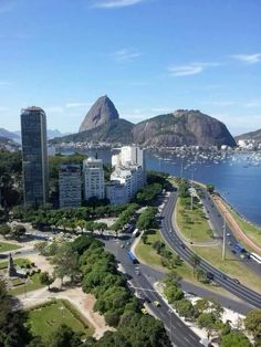 an aerial view of a city with mountains in the background and cars driving on the road