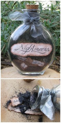 a bottle filled with black sand sitting on top of a wooden table