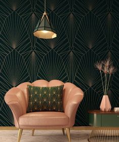 a pink chair sitting in front of a green wall with geometric designs on it and a gold lamp hanging from the ceiling