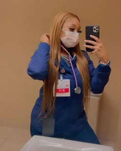 a woman in scrubs takes a selfie with her cell phone while sitting on a toilet