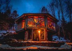 a cabin lit up at night in the snow