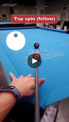 a man is playing pool on a blue billiards table with the words top spin follow