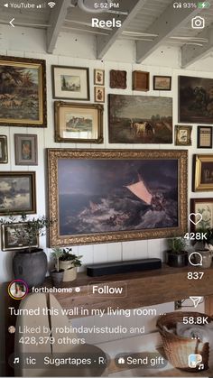 a living room filled with lots of pictures and paintings on the wall above a tv