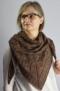 a woman with glasses wearing a brown knitted shawl