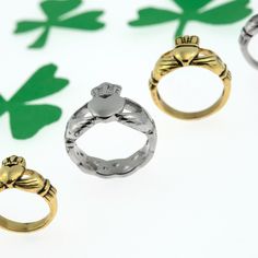 three gold and silver rings sitting next to each other on top of a white surface