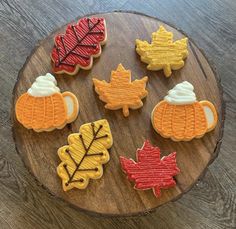 decorated cookies on a wooden platter with maple leaves