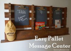 an easy pallet message center with chalkboards on it and a hat hanging from the wall