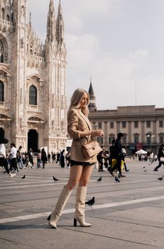 a woman is standing in front of a cathedral