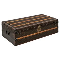 an old trunk is sitting on the floor in front of a white background and has stripes painted on it