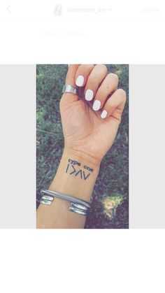 a woman's wrist with the word love tattooed on her left hand and an arrow tattoo