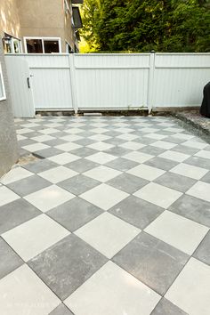 a black and white checkered tile floor in front of a fence