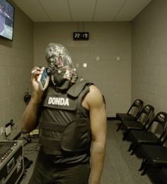 a man wearing a mask and holding a cell phone