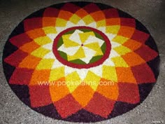 a circular carpet with an orange, yellow and red flower design