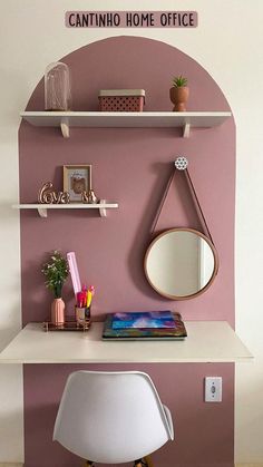 a desk with a mirror, chair and shelf above it in a room that has pink walls