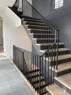 a staircase with black iron railing and wooden handrails in a modern style home