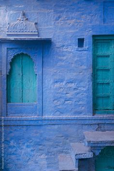 a blue building with green doors and steps