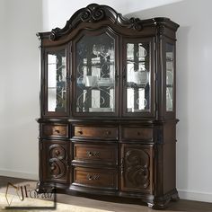 a large wooden china cabinet with glass doors