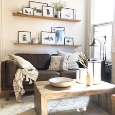 a living room filled with furniture and pictures on the wall above it's coffee table