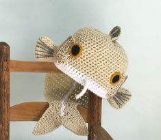 a crocheted fish sitting on top of a wooden chair