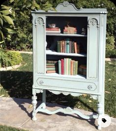 an old bookcase is painted blue and has books on it in the shape of a cabinet