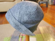 a gray hat sitting on top of a wooden stick