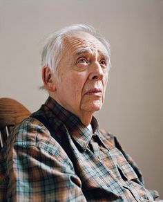 an old man sitting in a chair looking up