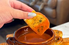 a person dipping some food into a bowl