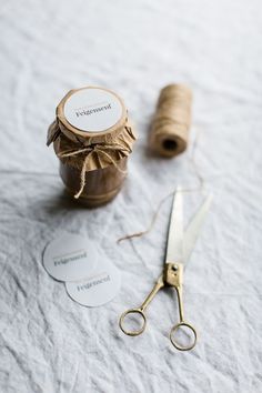 a pair of scissors sitting on top of a table next to some paper and twine