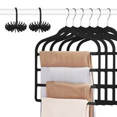 three black hangers and four white towels hanging on a rack