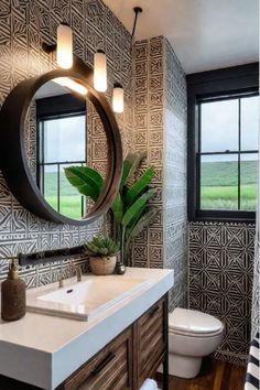 a bathroom with a mirror, sink and toilet next to a window in the room