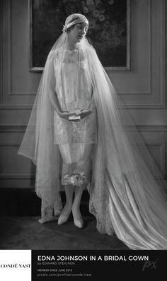 an old photo of a woman wearing a wedding dress and veil with her hands on her hips