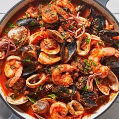 a pan filled with seafood and mussels