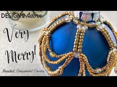 a blue ornament with gold beads on it and the words design & addn very merry