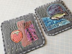 two square coasters with embroidered designs on them