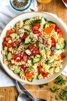 a pasta salad with tomatoes, cucumbers and other vegetables