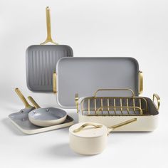 an assortment of kitchenware including pots, pans and utensils on a white background