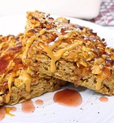 two pieces of food sitting on top of a white plate with caramel drizzle