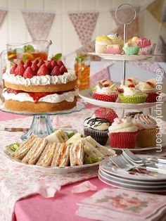 a table topped with lots of cakes and cupcakes