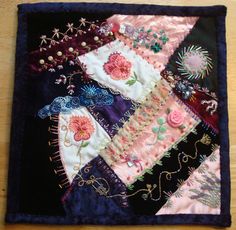 a close up of a piece of cloth on a wooden table with beads and flowers