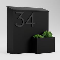 a black box with a green plant in it and the number 34 on the front