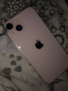 an iphone 11 is laying on a bed with its back facing the camera and two large black eyes