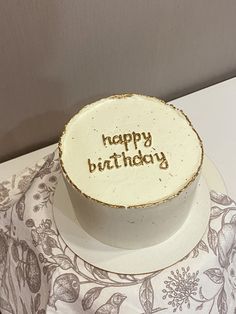 a birthday cake with the words happy birthday written on it sitting on a white plate