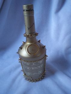 a bottle that is sitting on a blue cloth with some gold rivets around it