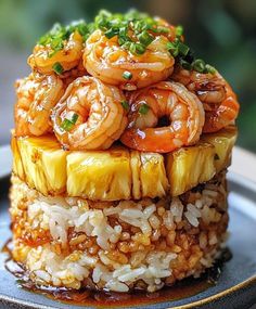 a plate topped with rice covered in shrimp and pineapple