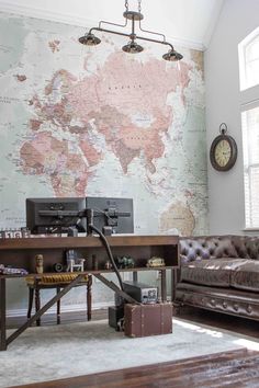 a living room with a map on the wall and leather furniture in front of it